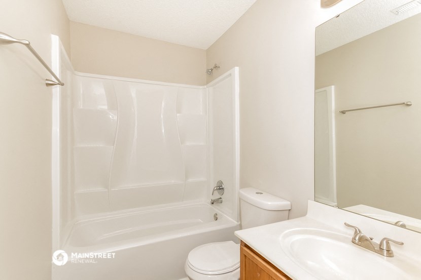 a bathroom with a shower and a sink and a toilet