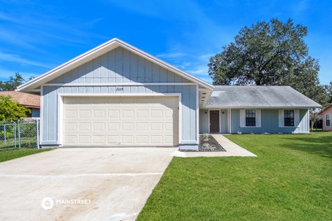 a white house with a white garage door and a lawn