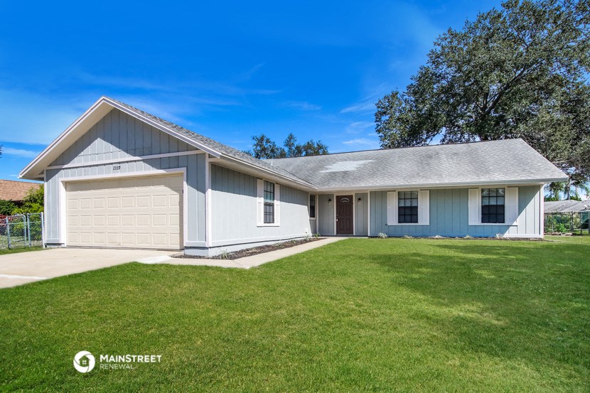 a white house with a lawn and a garage door