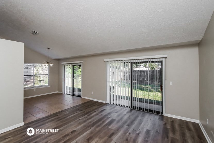 the spacious living room with wood flooring and sliding glass doors