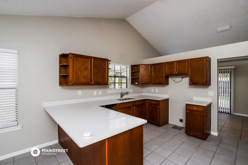 a kitchen with wooden cabinets and a white counter top