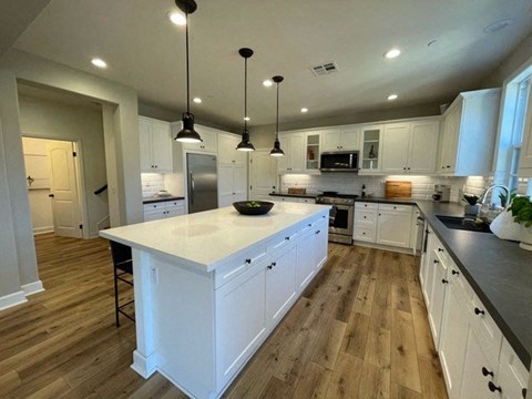 A kitchen with white cabinets and a large island.