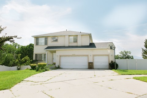 A two-story house with a garage and a driveway.