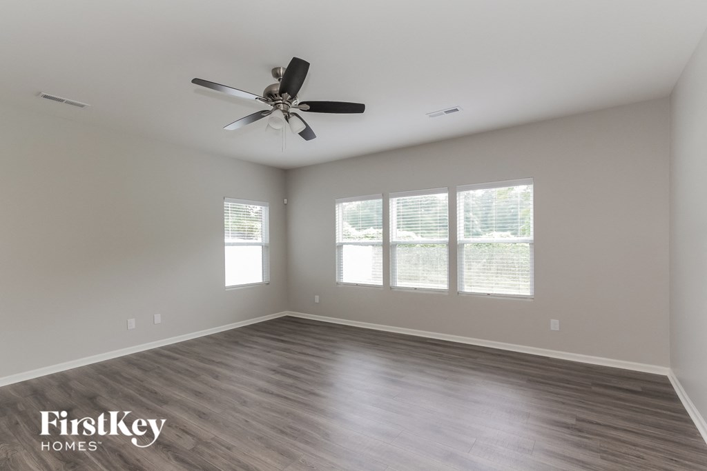 a living room with wood floors and a ceiling fan