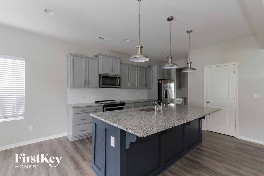 a kitchen with white cabinets and a granite counter top