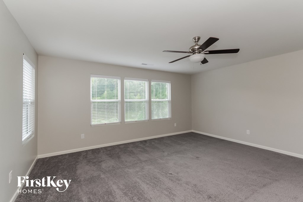 a living room with carpet and a ceiling fan