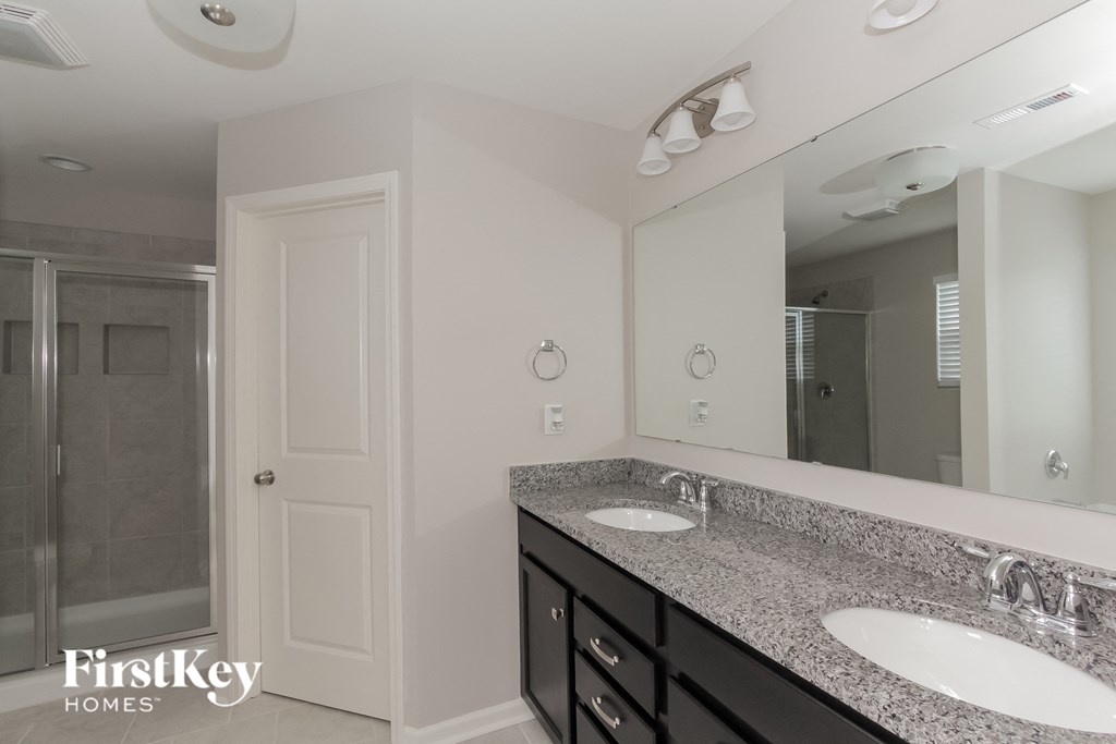 a bathroom with two sinks and a large mirror