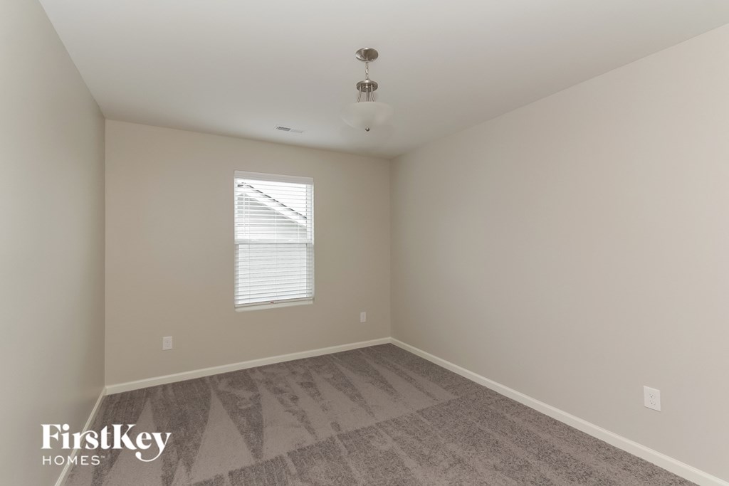 a bedroom with a carpeted floor and a window