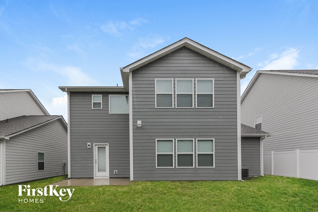 a gray house with a yard in front of it