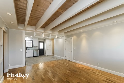 a living room with white walls and a wooden floor