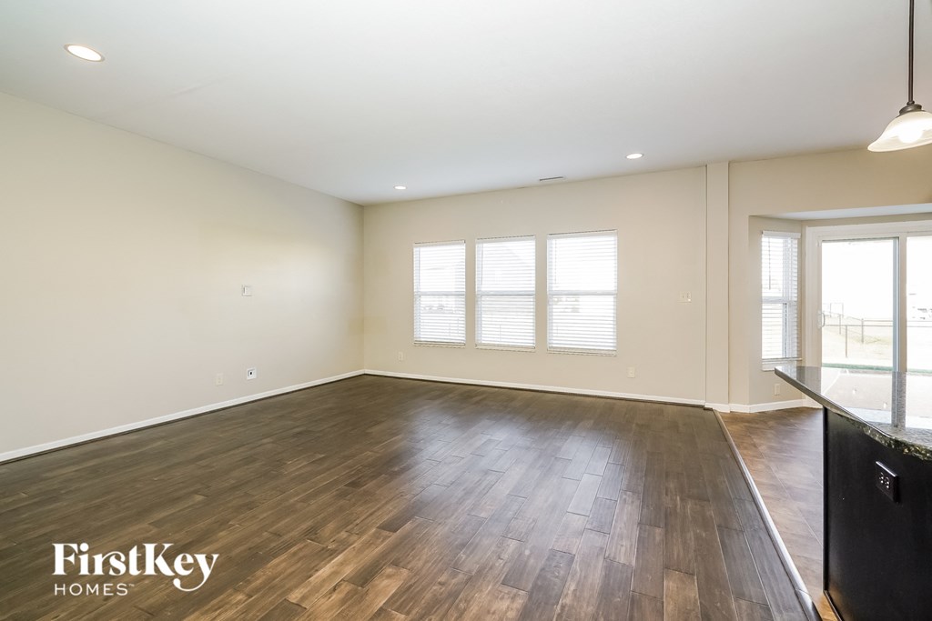 a living room with wood flooring and a large window