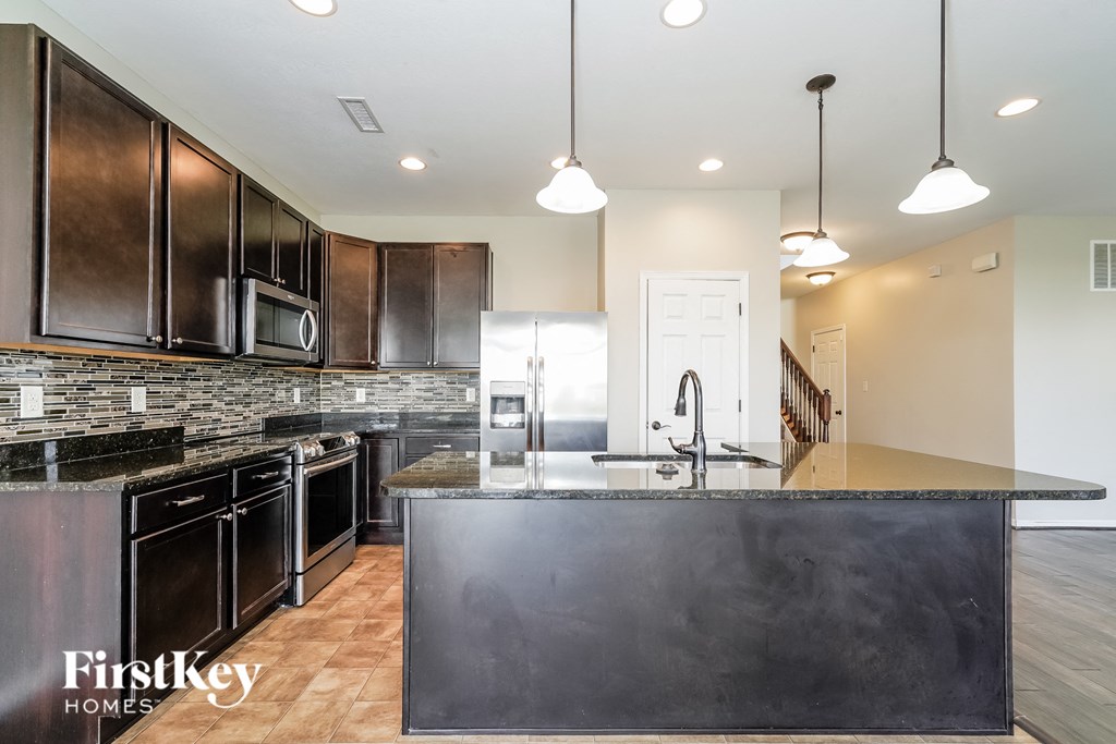 a kitchen with stainless steel appliances and a large counter top
