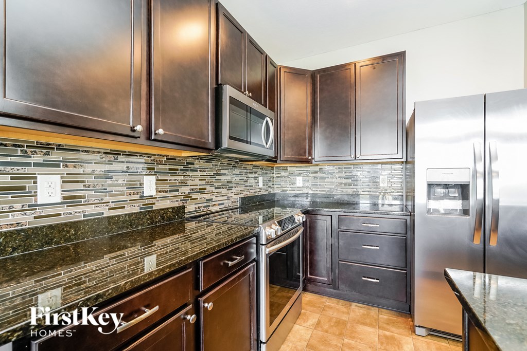 a kitchen with granite counter tops and stainless steel appliances