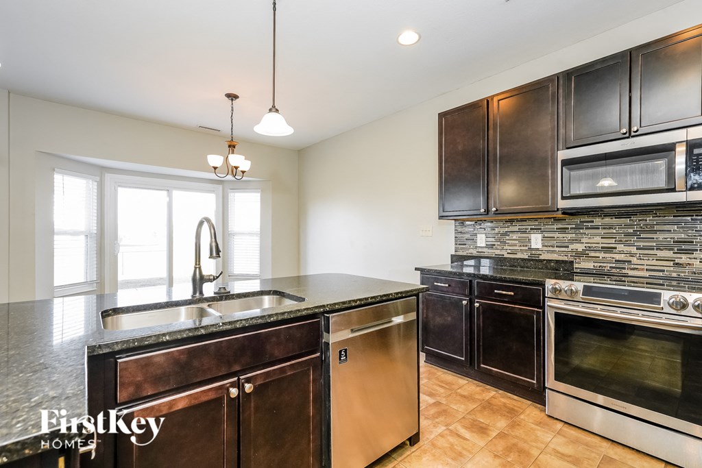 a kitchen with dark wood cabinets and stainless steel appliances