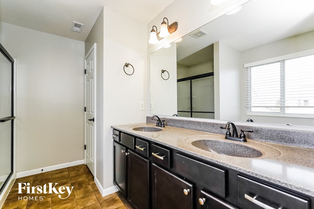 a bathroom with two sinks and a large mirror