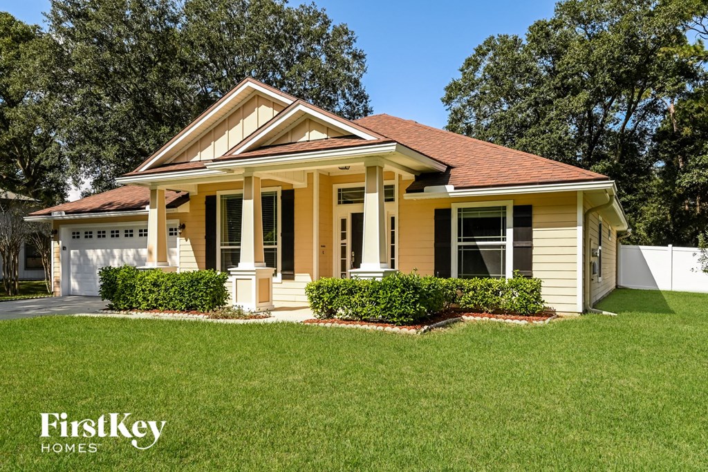 a small yellow house with a lawn in front of it