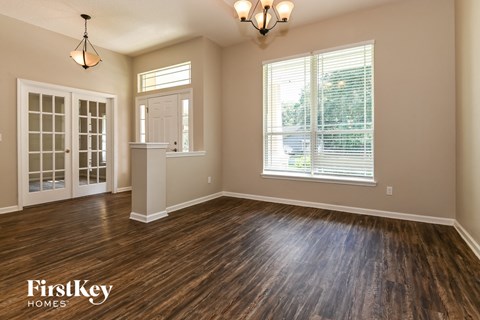 the living room of a home with a hardwood floor and a window