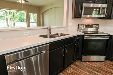 a kitchen with stainless steel appliances and white counter tops