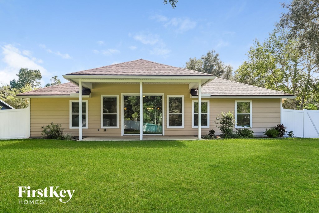 a beige house with a lawn in front of it