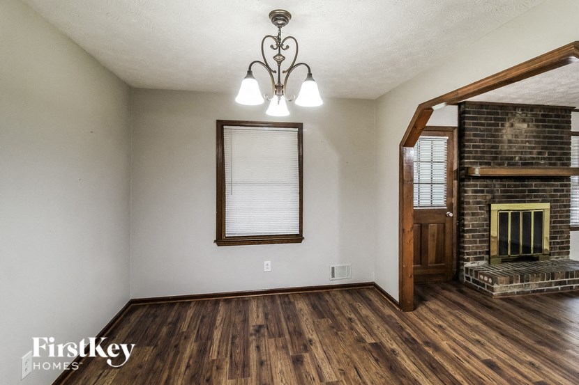 A room with a fireplace and a mirror on the wall.