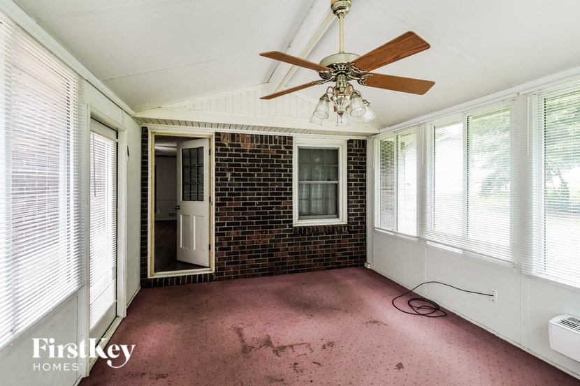A room with a brick wall and a ceiling fan.