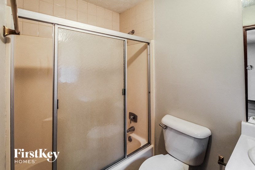 A FirstKey Homes branded bathroom with a toilet and a walk-in shower.