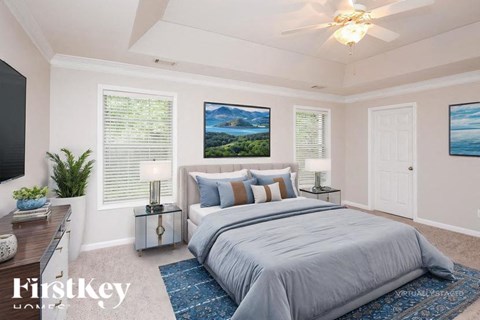 A bedroom with a large bed and a painting on the wall.