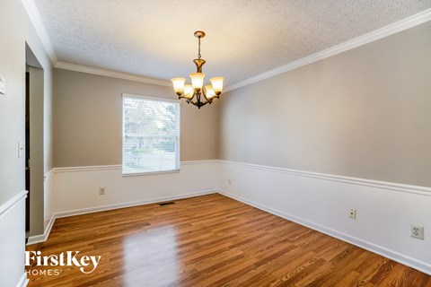the living room of a home with wood floors and a chandelier