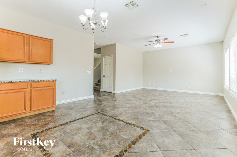 a kitchen and living room with tile flooring and wooden cabinets