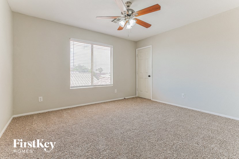 the living room of an empty house with a ceiling fan