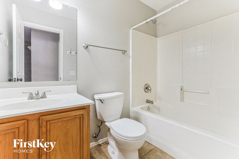 a bathroom with a toilet sink and tub and a mirror