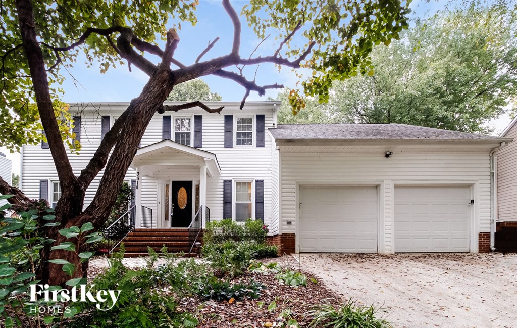 a white house with a tree in front of it