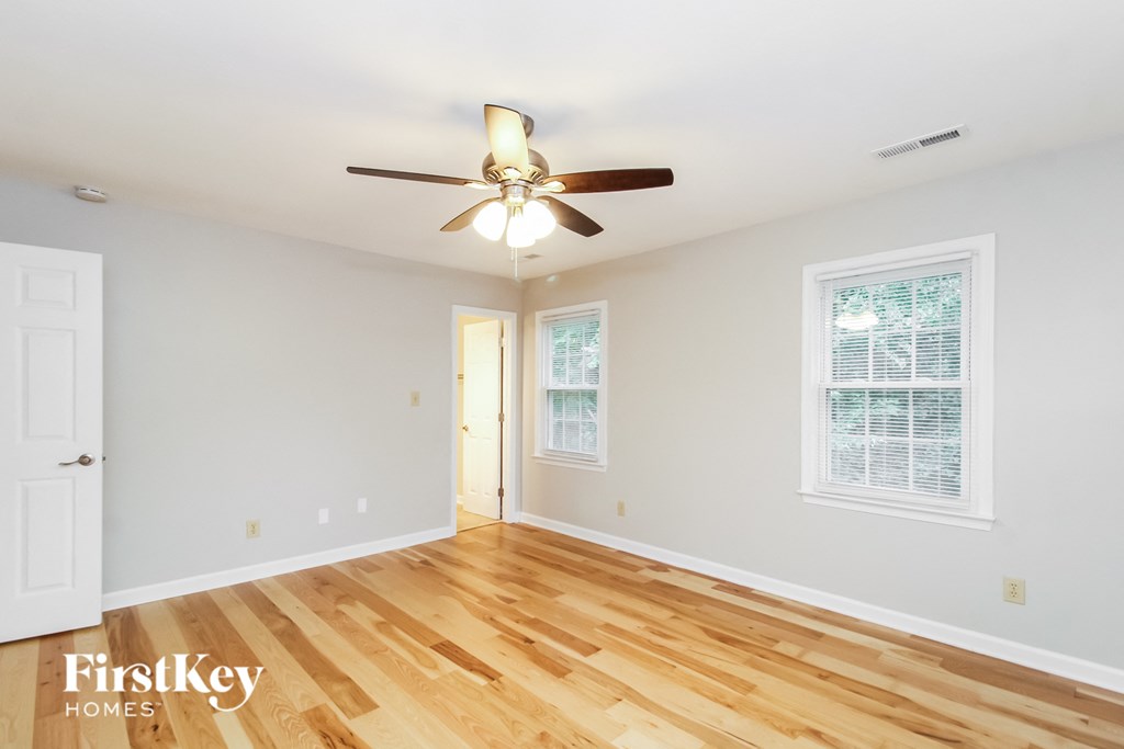 a living room with wood floors and a ceiling fan