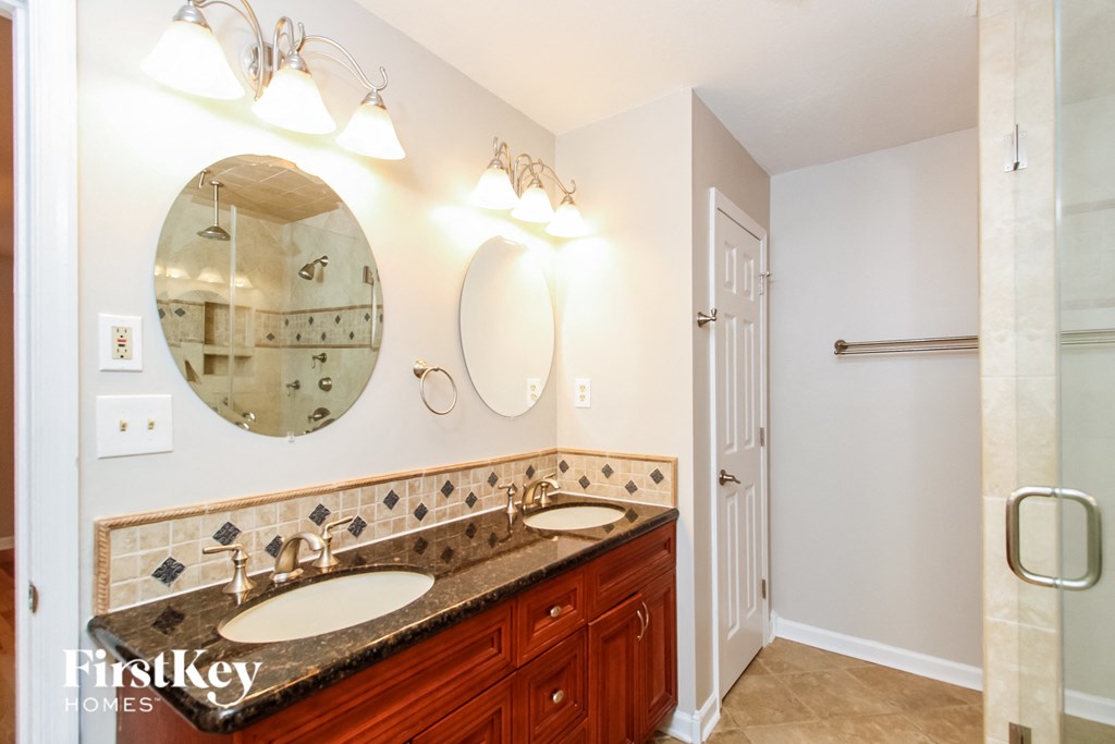 a bathroom with two sinks and a mirror and a shower