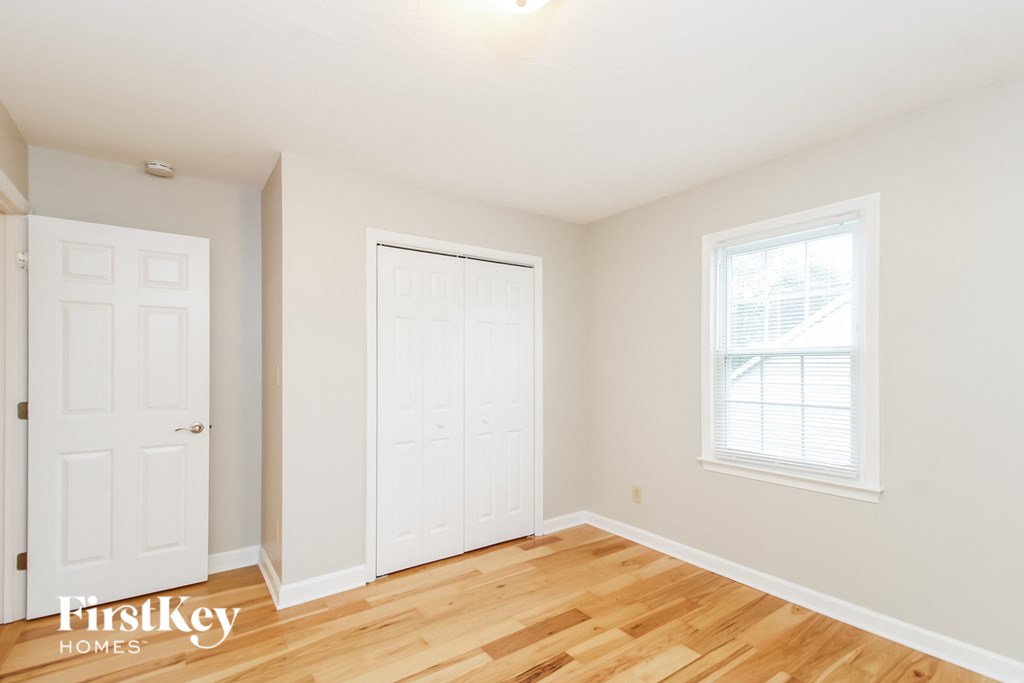 a bedroom with two white closets and a wood floor