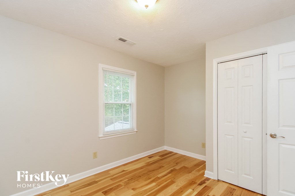 a bedroom with a wooden floor and a white door