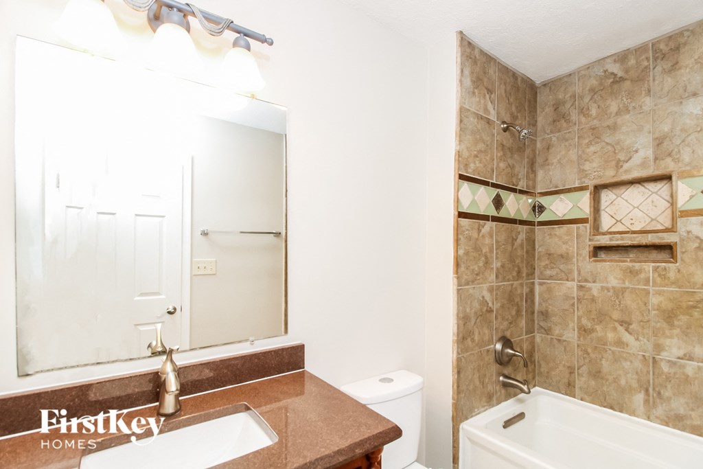 a bathroom with a sink toilet and shower and a mirror