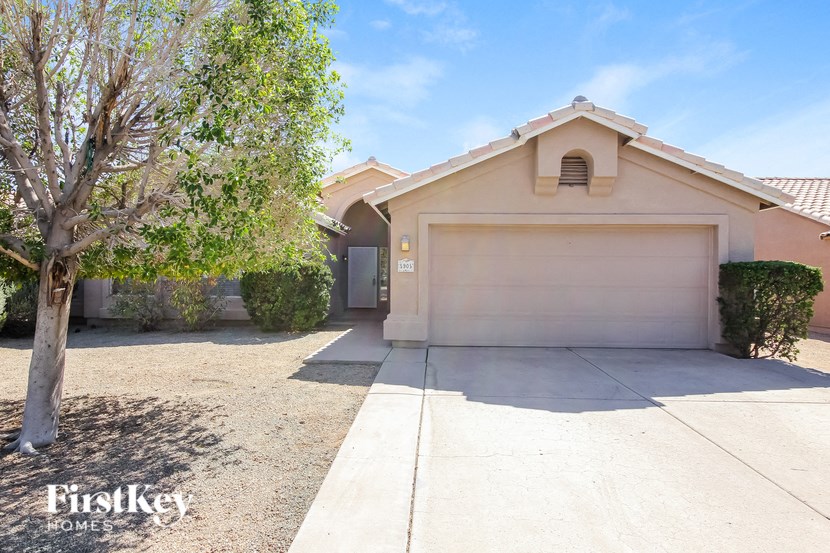 a home with a white garage door and a tree