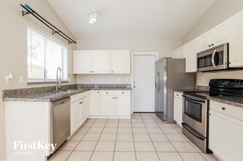 a kitchen with white cabinets and stainless steel appliances