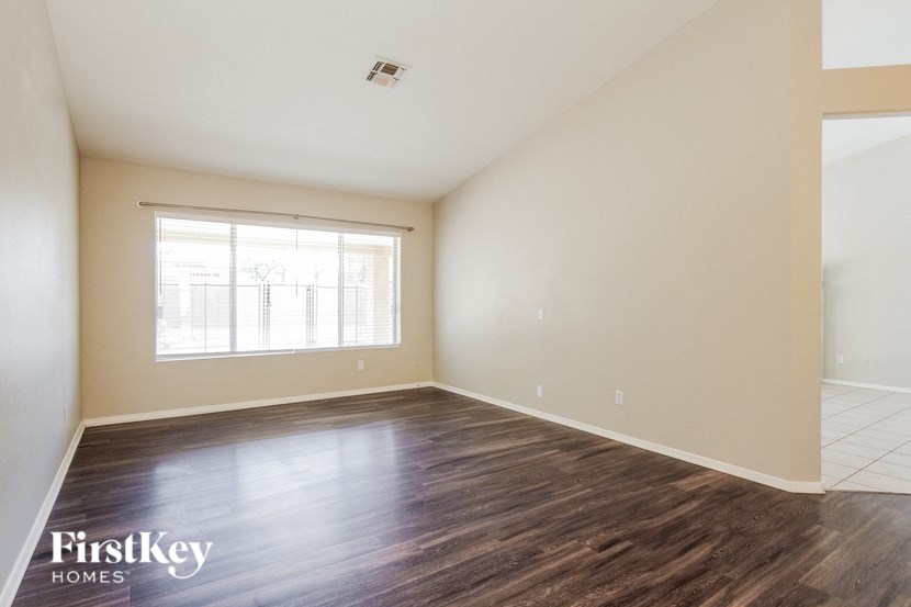 the spacious living room with hardwood flooring and a large window