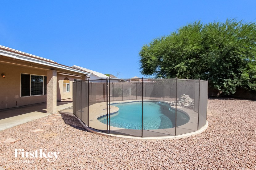 a round pool in the backyard of a house with a fence around it