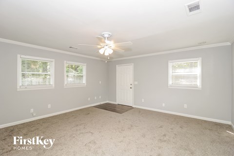 a bedroom with white carpet and a ceiling fan