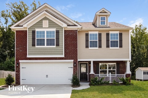 A two-story house with a garage and a small porch.