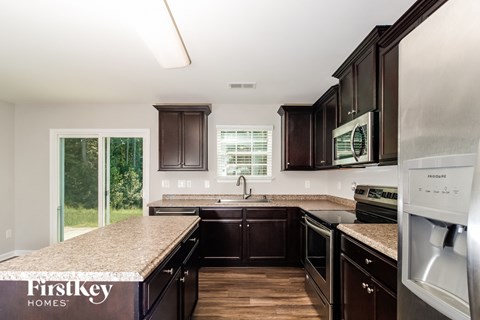A kitchen with dark wood cabinets and stainless steel appliances.
