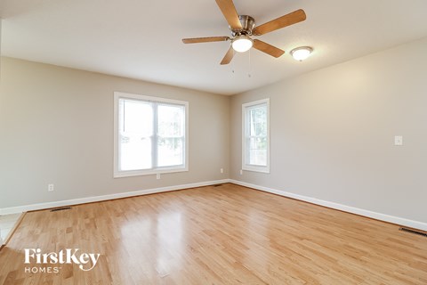 a living room with wood floors and a ceiling fan