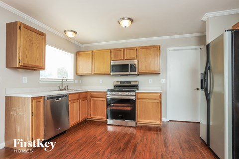 a kitchen with wooden cabinets and stainless steel appliances