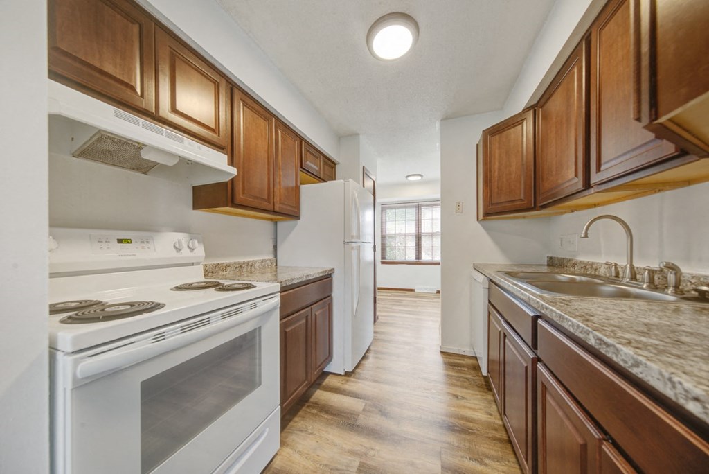 a kitchen with white appliances and wooden cabinets