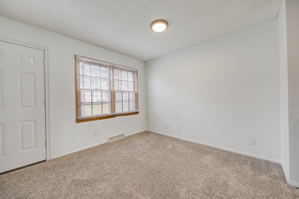 an empty living room with a window and a door