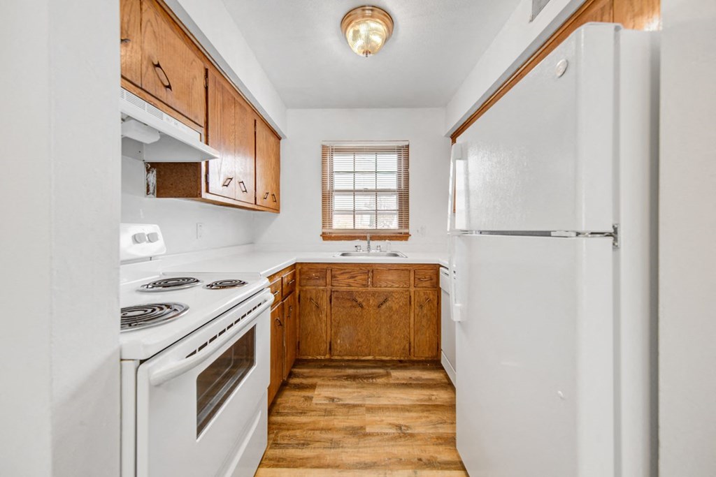 a kitchen with white appliances and wooden cabinets