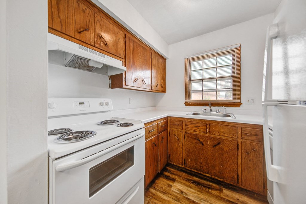a kitchen with white appliances and wooden cabinets